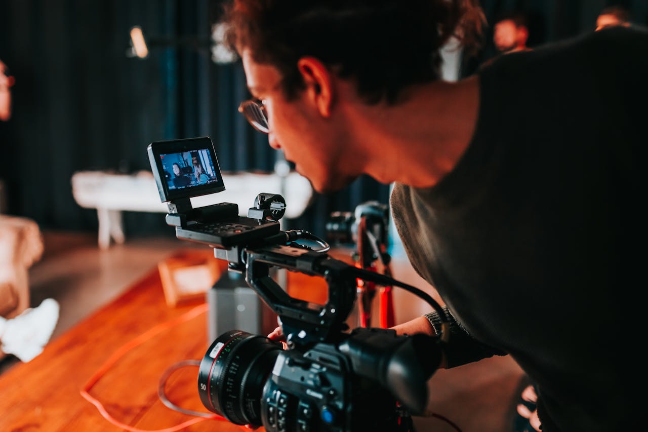 About Man filming on set with professional video camera in studio setting.