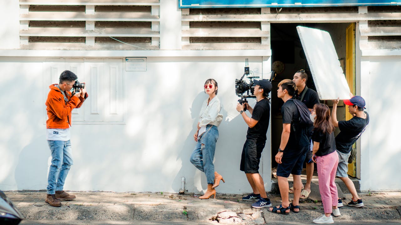 Home A film crew working outdoors using professional camera equipment for a video shoot.
